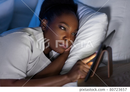 woman with tablet pc in bed at home at night 80723657