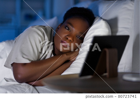 woman with tablet pc in bed at home at night woman with tablet pc in bed at home at night 80723741