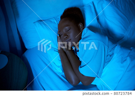 african woman sleeping in bed at home at night 80723784