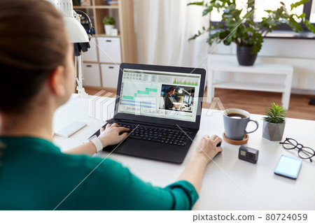 woman with video editor program on laptop at home 80724059