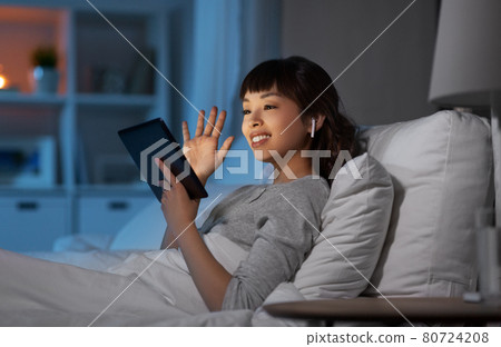 woman with tablet pc in bed has video call woman with tablet pc in bed has video call 80724208