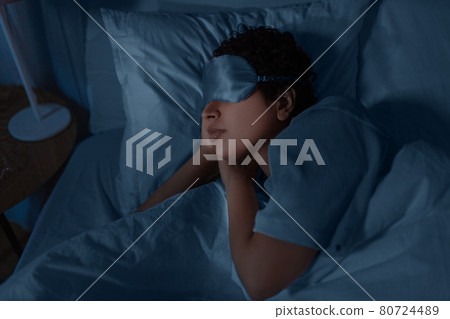 african woman sleeping in bed at home at night 80724489