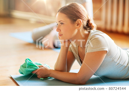 woman resting on yoga mat in gym or studio woman resting on yoga mat in gym or studio 80724544