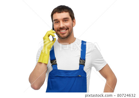 happy male worker or cleaner calling on smartphone 80724632