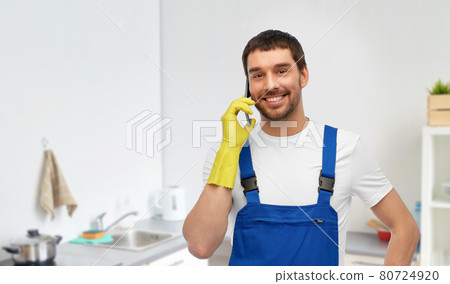 male worker or cleaner calling on phone at kitchen 80724920