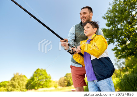 happy smiling father and son fishing on river 80724986