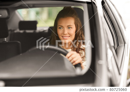 woman or female driver driving car in city 80725060
