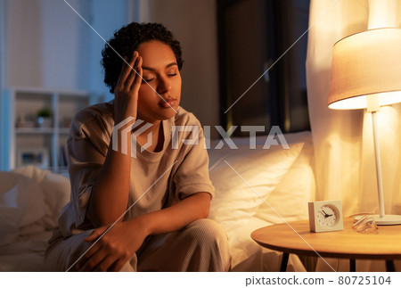 stressed african woman lying in bed at night 80725104