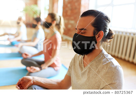 group of people in masks doing yoga at studio group of people in masks doing yoga at studio 80725367