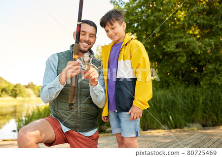 happy smiling father and son fishing on river 80725469