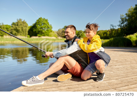 happy smiling father and son fishing on river 80725470