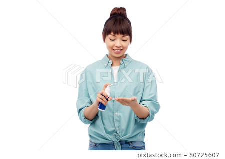 happy smiling asian woman using hand sanitizer 80725607