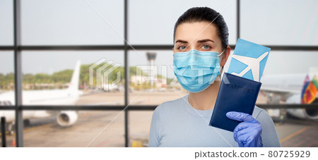 woman in mask with passport and ticket at airport woman in mask with passport and ticket at airport 80725929