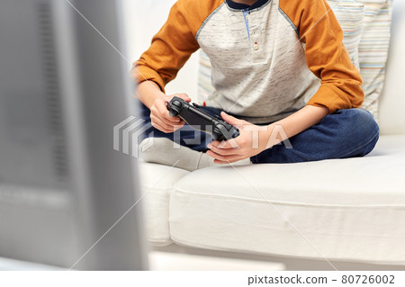 boy with gamepad playing video game at home boy with gamepad playing video game at home 80726002