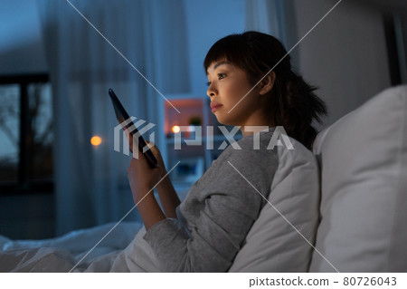 asian woman with tablet pc in bed at home at night 80726043