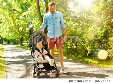 happy father with child in stroller at summer park 80726453