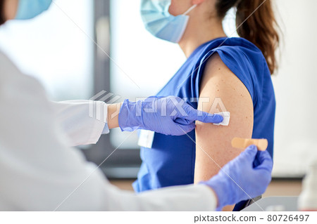 doctor attaching patch to medical worker 80726497