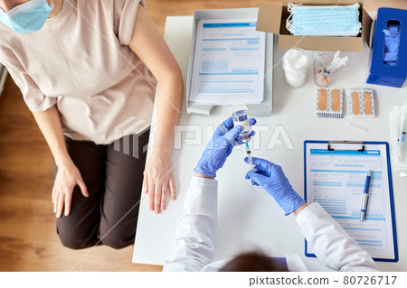 female doctor with syringe vaccinating patient female doctor with syringe vaccinating patient 80726717