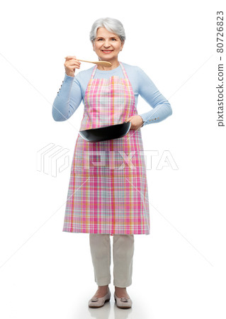 smiling senior woman in apron with frying pan 80726823
