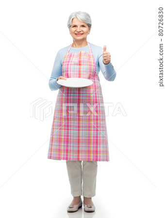 old woman in apron with plate showing thumbs up 80726830