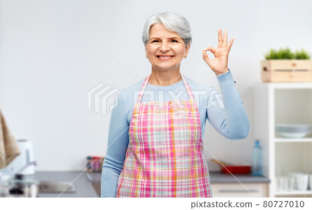 smiling senior woman showing ok gesture at kitchen smiling senior woman showing ok gesture at kitchen 80727010