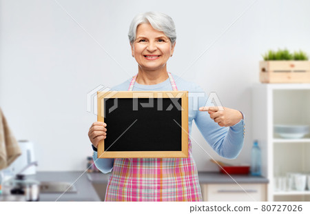 smiling senior woman with chalkboard at kitchen smiling senior woman with chalkboard at kitchen 80727026