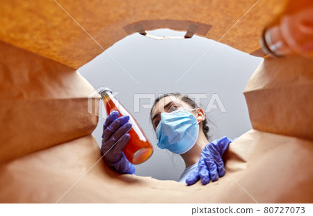 woman in gloves and mask with food in paper bag woman in gloves and mask with food in paper bag 80727073
