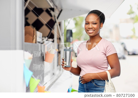 woman with tumbler and food in string bag 80727100