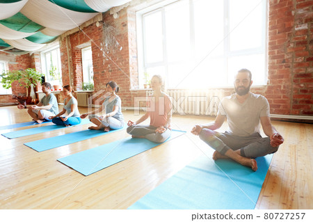 group of people meditating at yoga studio 80727257