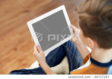 close up of boy with tablet pc computer at home close up of boy with tablet pc computer at home 80727287