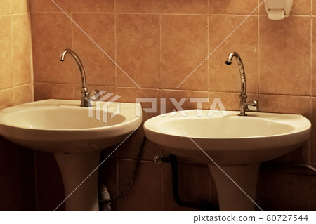 Two sinks with tap on background of tiles Two sinks with tap on background of tiles 80727544
