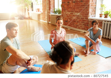 group of people resting on yoga mats at studio group of people resting on yoga mats at studio 80727545