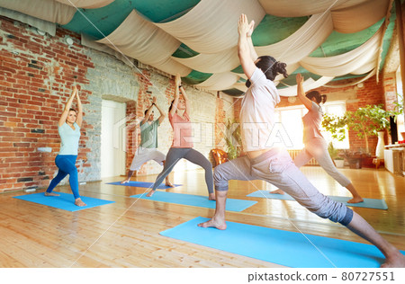 group of people doing yoga warrior pose at studio group of people doing yoga warrior pose at studio 80727551