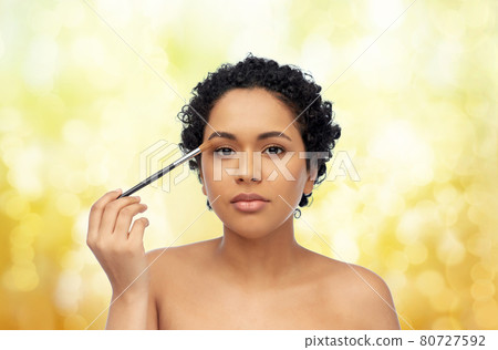 african american woman with make up brush african american woman with make up brush 80727592