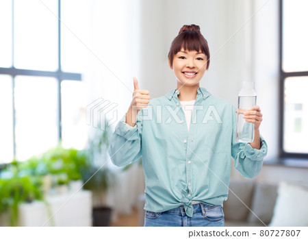 happy asian woman holding glass bottle with water happy asian woman holding glass bottle with water 80727807