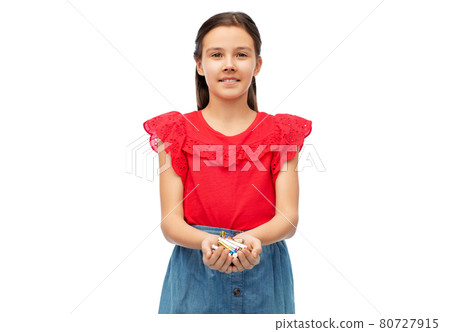 smiling girl holding pile of alkaline batteries 80727915