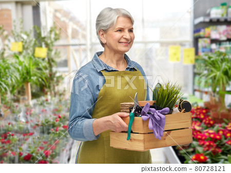 smiling senior woman with garden tools in box smiling senior woman with garden tools in box 80728121