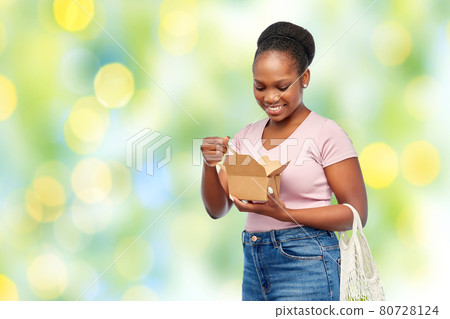 happy woman with reusable string bag eating wok 80728124