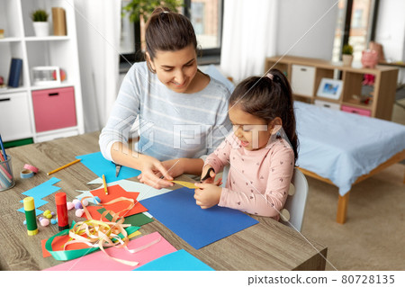 daughter with mother making applique at home 80728135