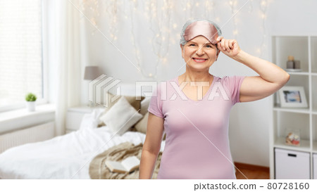 senior woman in pajamas and eye sleeping mask 80728160