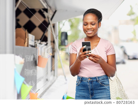woman with smartphone over food truck woman with smartphone over food truck 80728163