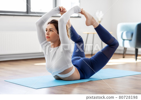 young woman doing bow pose at yoga studio young woman doing bow pose at yoga studio 80728198