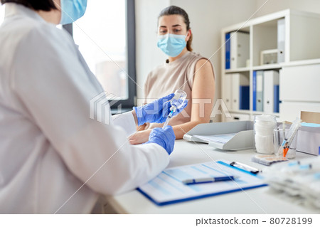 female doctor with syringe vaccinating patient female doctor with syringe vaccinating patient 80728199