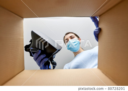 woman in mask taking vr glasses out of parcel box woman in mask taking vr glasses out of parcel box 80728201