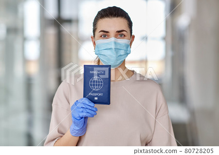 woman in mask and gloves holding immunity passport woman in mask and gloves holding immunity passport 80728205
