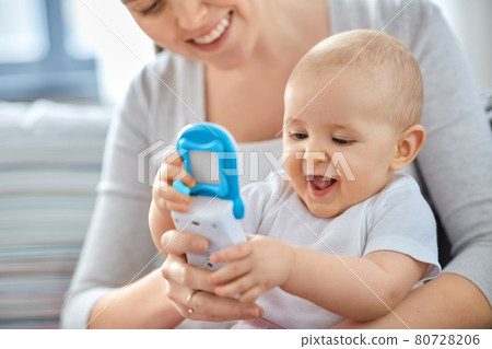 mother with baby playing with toy phone at home mother with baby playing with toy phone at home 80728206
