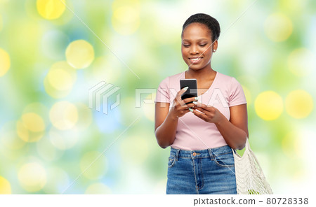 woman with smartphone and food in string bag woman with smartphone and food in string bag 80728338
