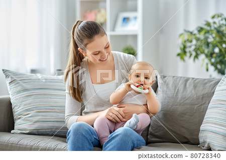 mother and little baby with teething toy at home 80728340