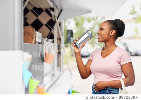 woman with tumbler and food in string bag 80728397