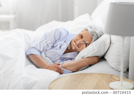 senior woman lying in bed at home bedroom senior woman lying in bed at home bedroom 80728433
